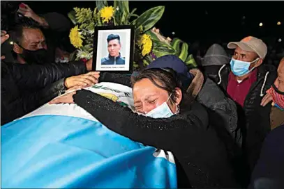  ?? MOISES CASTILLO / AP ?? A relative grieves over the coffin containing the remains of Ivan Pablo Tomas, one of the Guatemalan migrants who was killed near the U.S.-Mexico border in January, at a memorial Mass in a soccer stadium in Comitancil­lo, Guatemala, Friday. The migrants were among 19 people shot and burned in Camargo, located in the northern Mexican state of Tamaulipas on Jan. 22.