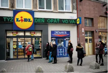  ?? — AFP photo ?? People queue in front of a supermarke­t in Bratislava downtown. Slovakia declared a two-week lockdown following a spike in Covid-19 cases.