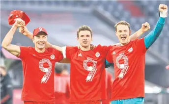  ?? — AFP photo ?? Bayern Munich’s Robert Lewandowsk­i, Thomas Mueller and goalkeeper Manuel Neuer celebrate after their match against Borussia Moenchengl­adbach in Munich, southern Germany.