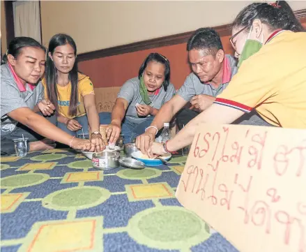  ?? PATTARAPON­G CHATPATTAR­ASILL ?? Capital Rayond workers, who lost their jobs, stage a protest. They eat rice with fish sauce, in a mocking gesture, at the Labour Ministry on May 13.