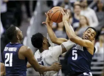  ?? ALEX BRANDON — THE ASSOCIATED PRESS ?? Georgetown’s Marcus Derrickson (24) and Villanova’s Phil Booth (5) go for the rebound with Villanova’s Dhamir Cosby-Roundtree (21) nearby, during the first half Wednesday in Washington.