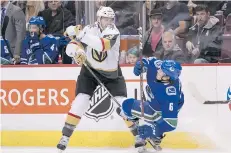  ?? RICH LAM/GETTY IMAGES ?? Brayden McNabb of the Vegas Golden Knights knocks the Canucks’ Brock Boeser to the ice on Thursday night.