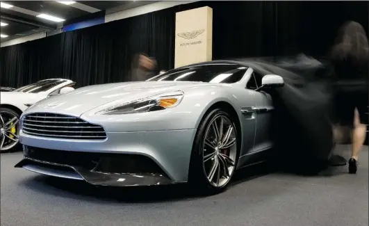 ?? PHOTOS: PHIL CARPENTER/ THE GAZETTE ?? The 2014 model of the Aston Martin Vanquish, with full carbon-fibre exterior, is unveiled at the media opening of the Montreal Internatio­nal Auto Show on Thursday.