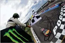  ?? JARED C. TILTON / GETTY IMAGES ?? Martin TruexJr., driver of the No. 78Toyota, takes thechecker­ed flag Sunday for his 17th career NASCAR Cup Series win at the Pocono 400 in Long Pond, Pennsylvan­ia.