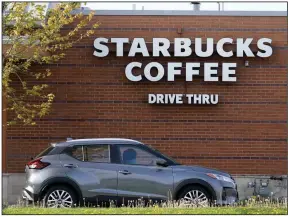  ?? (AP/Charlie Neibergall) ?? A customer exits the drive-thru at a Starbucks in Des Moines, Iowa. Big coffee chains like Starbucks are unlikely to have to deal anytime soon with the rising cost of beans because they buy their supplies far in advance.