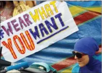  ?? THE ASSOCIATED PRESS ?? An activist protests outside the French embassy during, the “wear what you want beach party” in London Thursday. The protest is against the French authoritie­s clampdown on Muslim women wearing burkinis on the beach.