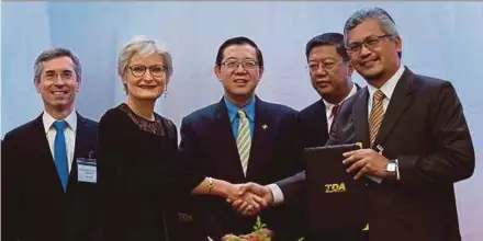  ?? PIC ?? (From left) Thales Internatio­nal Offsets vice-president for Southeast Asia Frederique Miller (second from left) exchanging documents with Technology Depository Agency chief executive officer Datuk Zailani Safari in Kulim, Kedah yesterday. With them are Finance Minister Lim Guan Eng (centre) and French ambassador Frederic Laplanche (left).BERNAMA