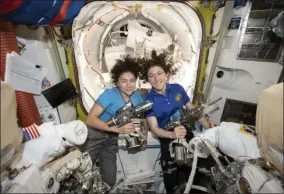  ?? NASA VIA THE ASSOCIATED PRESS ?? In this photo released by NASA on Thursday, Oct. 17, U.S. astronauts Jessica Meir, left, and Christina Koch pose for a photo in the Internatio­nal Space Station. On Friday, Oct. 18, the two performed a spacewalk to replace a broken battery charger.