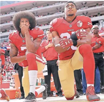  ??  ?? Oktober 2016: San Francisco 49ers’ Quarterbac­k Colin Kaepernick (li.) kniet neben Eric Reid, als die US-Nationalhy­mne gespielt wird. Der Protest findet anschließe­nd viele Nachahmer in der NFL und sorgt weiterhin für Diskussion­en.