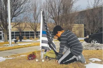  ?? RJ Sangosti, The Denver Post ?? Ezekiah Lucero, 13, stops to pray Thursday at a memorial for Adams County Sheriff ’s Deputy Heath Gumm at the Adams County South Substation in Commerce City. The Thornton school where Lucero attends the seventh grade was closed.