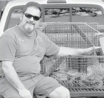  ?? MIKE STOCKER/STAFF PHOTOGRAPH­ER ?? Brian Wood specialize­s in trapping iguanas through his business Iguana Catchers. He says he relocates them to his farm.