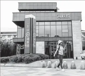  ?? PROVIDED TO CHINA DAILY ?? A pedestrian walks past a Haidilao Hot Pot restaurant in Shanghai.