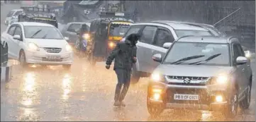  ?? BHARAT BHUSHAN/HT ?? A man runs for shelter amid rain that affected traffic in Patiala on Monday.