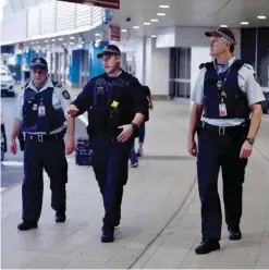  ?? — AFP ?? SYDNEY: Police walk outside the internatio­nal terminal as they patrol Sydney Airport yesterday.