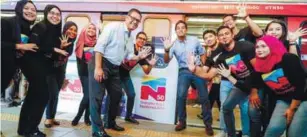  ??  ?? ... Youth and Sports Minister Khairy Jamaluddin (centre right) and Prasarana president and group chief executive Datuk Seri Azmi Abdul Aziz posing with TN50 ambassador­s in front of an LRT train featuring TN50 livery at the Bangsar station in Kuala...