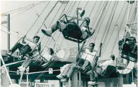  ?? BALTIMORE SUN ?? Fairgoers enjoy a ride during the 1987 Baltimore City Fair.