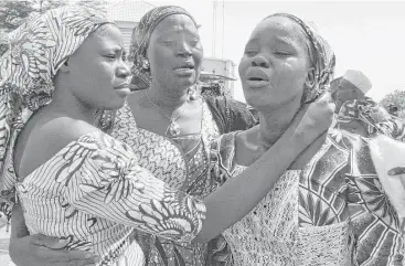  ?? Olamikan Gbemiga / Associated Press ?? Family members celebrate as they embrace a relative, one of the released kidnapped schoolgirl­s, in Abuja, Nigeria. In 2014, extremists kidnapped 276 girls from remote Chibok; 113 remain in captivity.