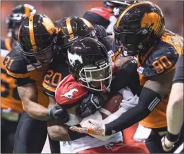  ?? The Canadian Press ?? B.C. Lions defenders Otha Foster III (31), Bo Lokombo (20) and Davon Coleman (90) gang tackle Don Jackson of the Calgary Stampeders during their CFL regular-season finale in Vancouver last Saturday.