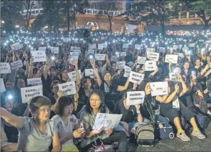  ?? / C. COURT (GETTY) ?? Protesta de madres, con carteles y móviles, ayer cerca del Parlamento en Hong Kong.