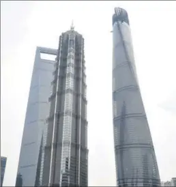  ?? YAN DAMING / FOR CHINA DAILY ?? The 632-meter Shanghai Tower (right), located in Lujiazui, Shanghai’s financial zone, is scheduled for completion in 2015. It is the second-tallest building in the world.