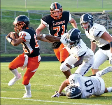  ?? Westside Eagle Observer/MIKE ECKELS ?? (Above photo) Gravette’s Tajae White (12) breaks away from a squad of Commandos late in the first half for a 60-yard run for the only Lions’ touchdown of the game. (Right photo) White looks downfield for one of his receivers early in the third quarter of the Gravette-Cascia Hall game at Lions Stadium in Gravette on Aug. 24.