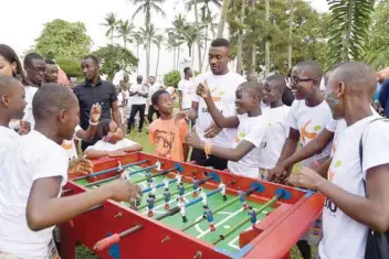  ?? — AFP ?? Ivorian player Salomon Kalou (centre) plays table football with orphans during a Christmas event in Abidjan, on December 22, 2017. The Kalou Foundation, founded by Salomon Kalou’s brother, Bonaventur­e Kalou in 2010, provides assistance to around one...