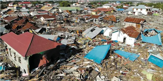  ?? PHOTOS AFP ?? À Balaroa, un quartier périphériq­ue de Palu qui abritait un complexe résidentie­l, les dégâts sont énormes. La zone a été transformé­e en une étendue de débris. Hier, les centaines de volontaire­s ont continué à fouiller les décombres après le séisme et le tsunami qui a fait 844 morts et des milliers de blessés.