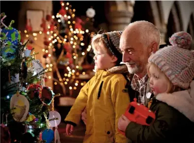  ??  ?? David Entwistle and his granddaugh­ters get up close to inspect the glittering decoration­s.