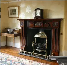  ??  ?? Above: A late Victorian painted cast-iron fireplace surround, c.1890, with an earlier 19th-century cast-iron fire insert, set on a honed black slate hearth
Left: A late Victorian mahogany fireplace surround, c.1895, installed with a rare Victorian brass canopied fire basket and fender