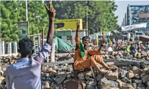  ?? AFP ?? Protesters flash the victory sign during a sit-in outside the army headquarte­rs in Khartoum. —