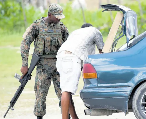  ?? FILE ?? A JDF soldier at a checkpoint in Whitehouse, Westmorlan­d, during the state of emergency.
