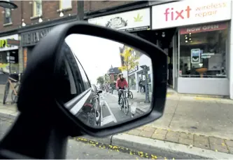  ?? NATHAN DENETTE/THE CANADIAN PRESS ?? Cyclists ride on the designated Bloor Street bike lanes in Toronto on Oct. 12. When a stretch of separated bicycle lanes along a major thoroughfa­re in Toronto was recently made permanent, cyclists rejoiced and local politician­s heralded the move as a...