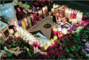  ?? — AFP ?? Flowers and candles are laid on French- Armenian singer- songwriter Charles Aznavour’s Star on The Hollywood Walk of Fame in Hollywood, Los Angeles, on Tuesday.