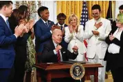  ?? NICHOLAS KAMM / AFP ?? President Joe Biden (center) reacts after signing an executive order advancing equality for LGBTQ Individual­s during a reception celebratin­g Pride Month on Wednesday in the White House.
