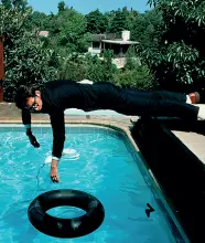  ??  ?? Elvis Costello L’artista sospeso nell’aria Uno scatto che ha fatto storia quello del cantante italoameri­cano che si protende verso la piscina nell’interno di «Arnmed Forces» del 1978