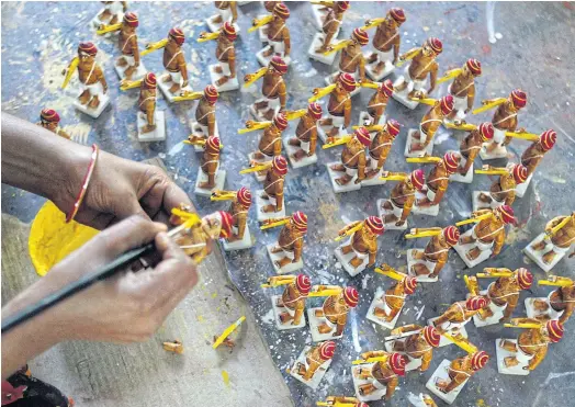  ??  ?? PATIENT WORK: An Indian artisan applies vegetable paint to toys at a workshop in Kondapalli village in Vijayawada district of Andhra Pradesh state.