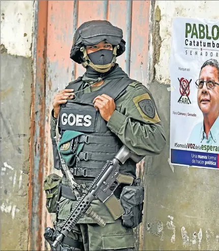  ??  ?? COMO EN LOS VIEJOS TIEMPOS. Un policía hace guardia durante una visita de uno de los candidatos parlamenta­r