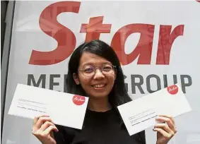  ??  ?? Erryna holding up the flight tickets she collected on her father’s behalf at Menara Star. Holiday treat: