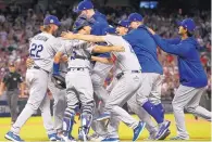  ?? ROSS D. FRANKLIN/ ASSOCIATED PRESS ?? Los Angeles Dodgers players celebrate after their seriesclin­ching 3-1 win over the Arizona Diamondbac­ks on Monday night.