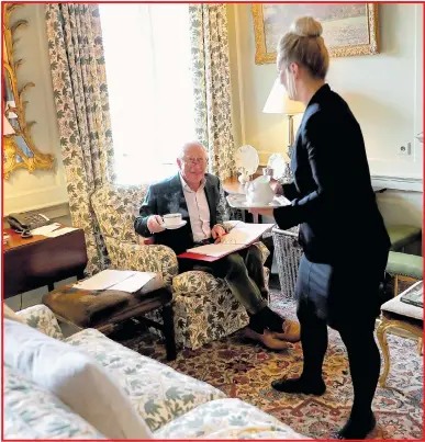  ??  ?? Service with a smile... Charles is served tea in a sitting room at Dumfries House in Ayrshire in May