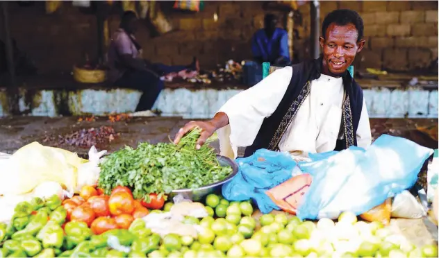  ?? Reuters ?? ↑ A Sudanese vendor sells fruits and vegetables at a bazaar in Khartoum on Monday.