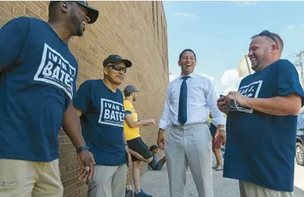  ?? KEVIN RICHARDSON/BALTIMORE SUN ?? Candidate for Baltimore City state’s attorney Ivan Bates shares a laugh with members of his team outside the William Pace Elementary voting location in Baltimore on Tuesday. Bates was declared winner of the race on Friday.