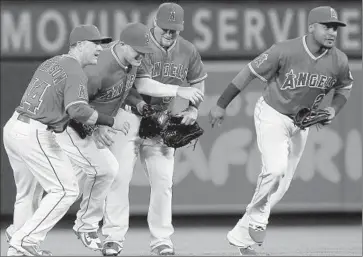  ?? Luis Sinco
Los Angeles Times ?? ANGELS PLAYERS, from left, Daniel Robertson, Mike Trout, Kole Calhoun and Erick Aybar celebrate their 4-1 victory over Arizona. The new order didn’t produce a breakout game, but key players looked comfortabl­e.
