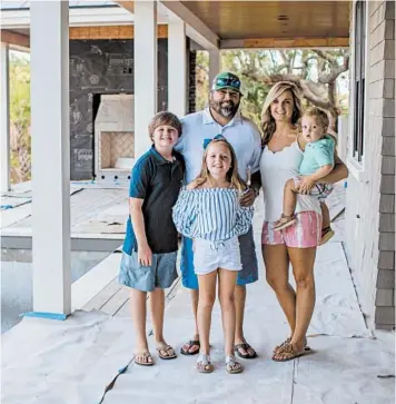  ?? HUNTER MCRAE/THE NEW YORK TIMES ?? Todd and Heather Wigfield with their children at their home under constructi­on July 16 in Mount Pleasant, South Carolina.