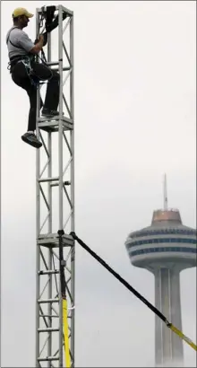  ?? Photos, David Duprey, Associated Press ?? Scott O’Shea rigs a tower in preparatio­n for Nik Wallenda’s tightrope walk in Niagara Falls, N.Y. Wallenda estimates his history-making, U.S.-to-Canada walk will cost $1.2 million to $1.3 million.