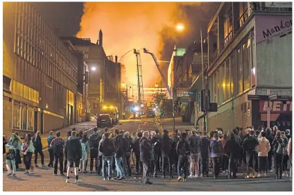  ??  ?? Crowds watch in horror as art school goes up in June last year, the second devastatin­g blaze in four years