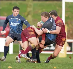  ??  ?? ●● Ryan Parkinson tackled supported by Tom Eaton