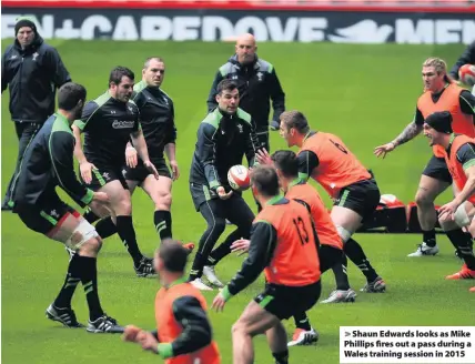  ??  ?? > Shaun Edwards looks as Mike Phillips fires out a pass during a Wales training session in 2015