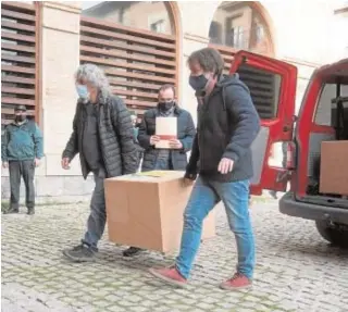  ?? EFE ?? Dos operarios transporta­n una caja a su llegada a Barbastro