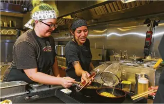  ?? Mark Mulligan / Houston Chronicle ?? Line cooks Gina Schwaderer, left, and Jocelyn Noria prepare ramen in the kitchen at Ramen Tatsu-ya in Montrose. Sun Noodle’s factory will add to Houston’s culinary culture.